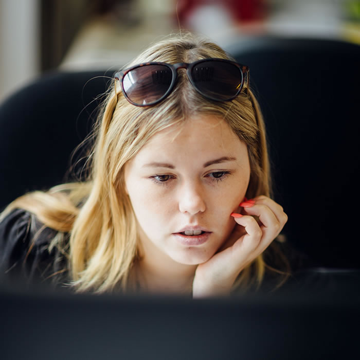 woman with sunglasses sitting at computer